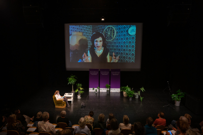 Den finske forfatter Sofi Oksanen med live på storskærm på Godsbanen fra sit hjem i samtale med prodekan Anne Marie Kragh Pahuus.