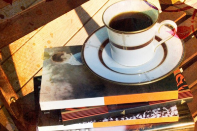 En kaffekop oven på en stak bøger