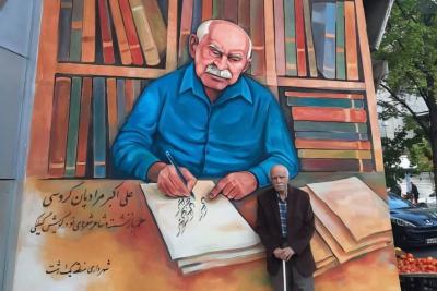 Ali Akbar Moradian Garousi foran vægmaleri af sig selv.