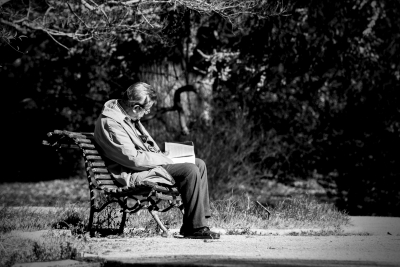 mand, der sidder på en bænk og læser