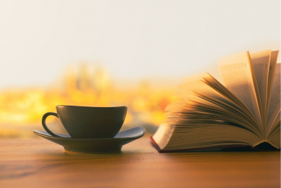 Kaffekop ved siden af opslået bog