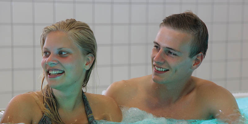 En dreng og en pige, der sidder i Grossererbadet
